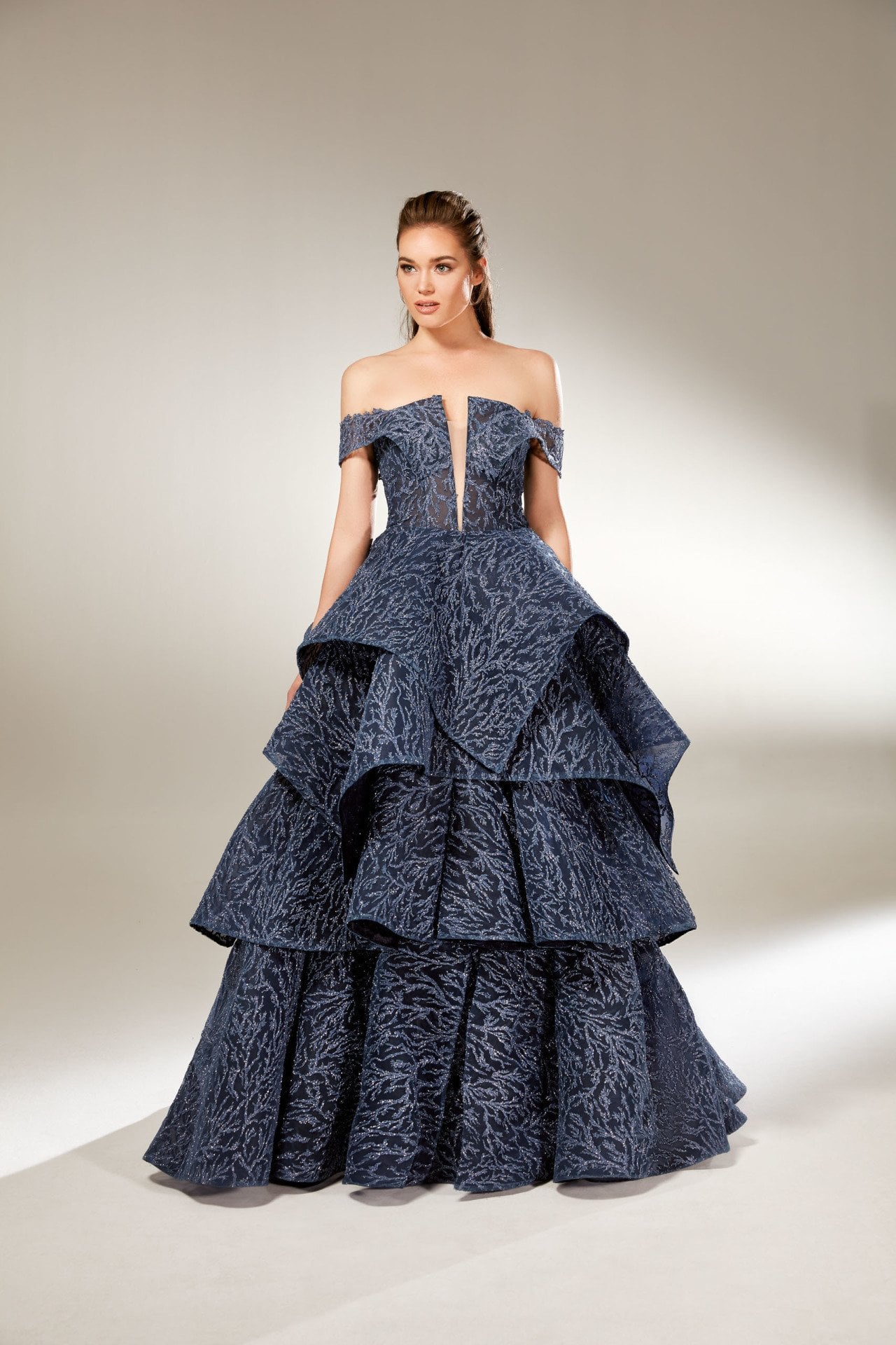 Modelo de vestido de noche brillante con detalle de manga lateral, falda en capas, cuerpo semitransparente